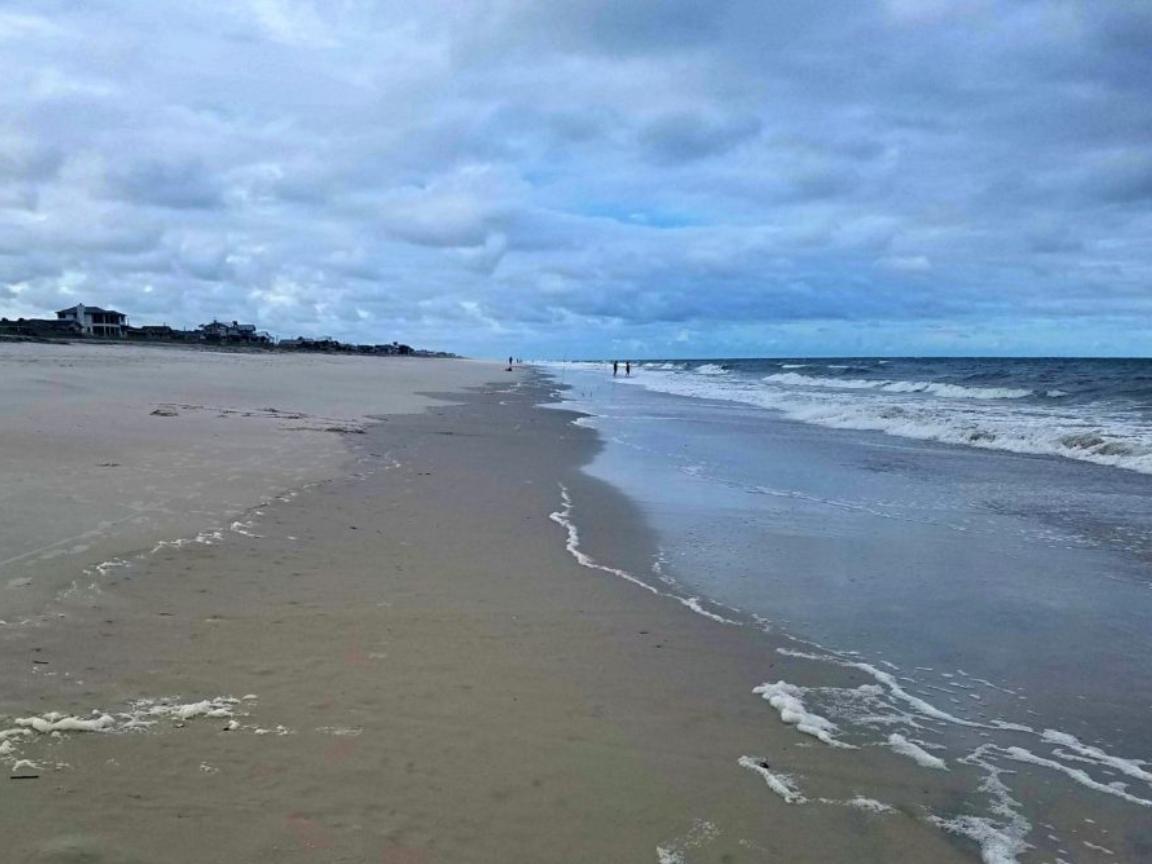 13 Romantic Beaches in Florida Offer the Perfect Couple's Getaway 4 A wide sand beach stretches into the distance and meets the Atlantic Ocean on the right side of the photo.