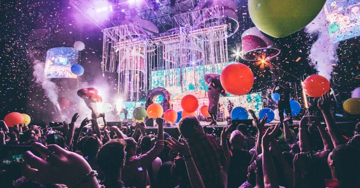 Lights, balloons, and a crowd at a music festival.